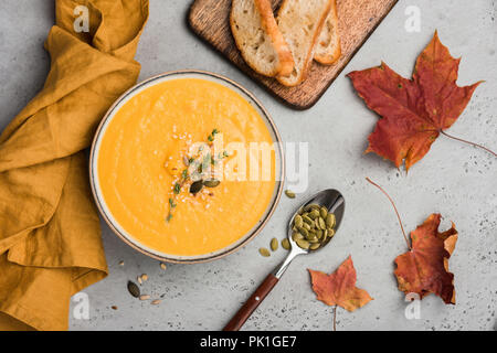 Kürbis Suppe pürieren oder Creme Suppe in der Schüssel. Herbst Komfort Essen auf konkreten Hintergrund. Wärmende Suppe Stockfoto