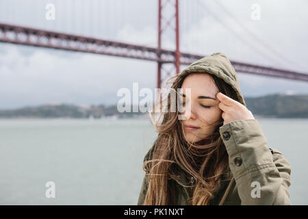 Portrait einer jungen schönen Mädchen, ihr Haar in windigen Wetter draußen in Lissabon begradigt. Stockfoto