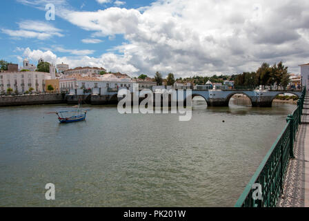 Traditionelle portugiesische Fischerboot vor der römischen Brücke in Rio Gilao Tavira Portugal Flusslandschaft Stadtbild Blick auf traditionellen typischen Blau wh Stockfoto