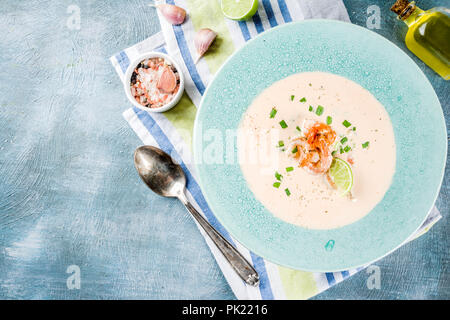 Mediterran Italienisch traditionelles Essen, hausgemachte Gemüse Meeresfrüchte cremige Suppe mit Garnelen Garnelen, Kalk und Kräuter, Hellblau konkreten Hintergrund kopieren Stockfoto
