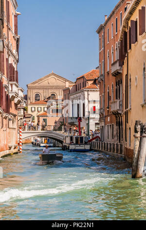 Schmalen Kanal in Venedig, mit Touristen zu Fuß über eine Brücke. Stockfoto