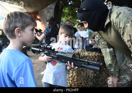 Thessaloniki, Griechenland. 10 Sep, 2018. Ein Junge hält das Gewehr eines Griechischen Army Special Forces Soldaten an der Internationalen Messe Thessaloniki. Die Internationale Messe von Thessaloniki ist eine jährliche internationale Ausstellung Veranstaltung in Thessaloniki mit der Teilnahme der USA hielt, als das Land in diesem Jahr geehrt. Credit: Giannis Papanikos/ZUMA Draht/Alamy leben Nachrichten Stockfoto