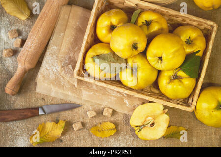 Eine Menge apple Quitte mit Küchenutensilien, Vorbereitung für die Quitte pie Sacktuch rustikalen Hintergrund. Stockfoto