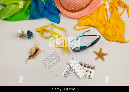 Sommer der Frauen Strand Zubehör für Ihr Meer Urlaub und Pille auf weißem Hintergrund. Konzept der Medikation in Reise erforderlich. Ansicht von oben. Stockfoto