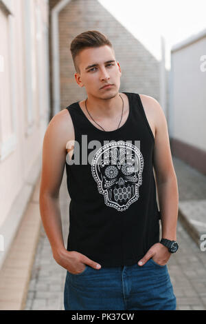 Porträt der jungen stilvollen Mann in einem schwarzen T-Shirt mit einem Totenschädel. Stockfoto