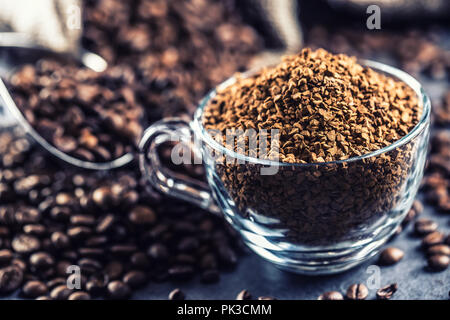 Granulat von Instant Kaffee im Glas Schale und Kaffeebohnen. Stockfoto
