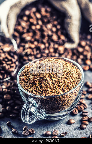 Granulat von Instant Kaffee im Glas Schale und Kaffeebohnen. Stockfoto