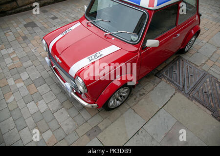 Ein roter Mini Cooper mit einem Union Jack Dach von John Cooper Version des Mini auf einer gepflasterten Straße in Huddersfield geparkt Stockfoto
