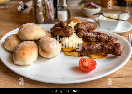 Platte mit cevapcici, Hackfleisch Kebab mit Chips auf einem Tisch Stockfoto