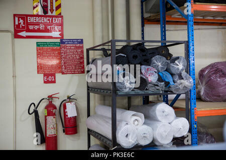 Feuerlöscher und Notausgang Schild in einer Textilfabrik in Bangladesch. Stockfoto