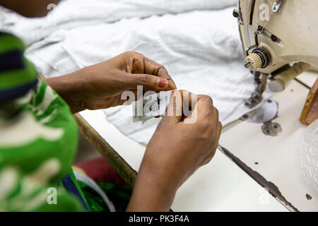 Ein Etikett in ein T-Shirt in einer Textilfabrik in Bangladesch genäht. Stockfoto