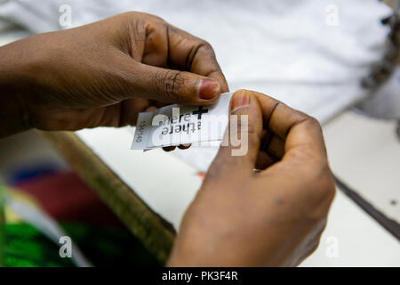 Ein Etikett in ein T-Shirt in einer Textilfabrik in Bangladesch genäht. Stockfoto