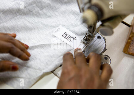 Ein Etikett in ein T-Shirt in einer Textilfabrik in Bangladesch genäht. Stockfoto