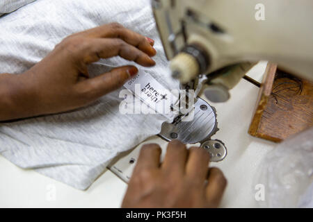 Ein Etikett in ein T-Shirt in einer Textilfabrik in Bangladesch genäht. Stockfoto