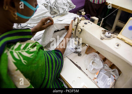 Ein Etikett in ein T-Shirt in einer Textilfabrik in Bangladesch genäht. Stockfoto