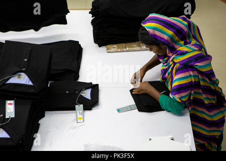 Eine Näherin Falten Kleidung in einer Textilfabrik in Bangladesch. Stockfoto