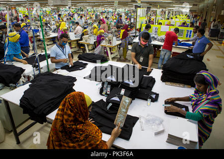 Textilarbeiterinnen Falten Kleidung in einer Textilfabrik in Bangladesch. Stockfoto