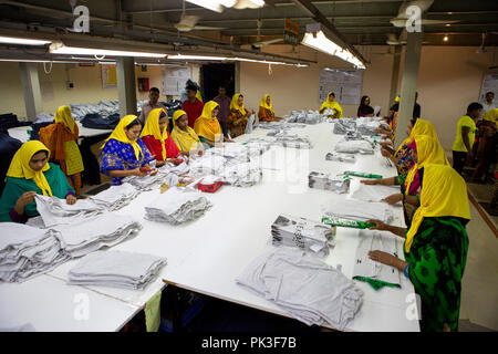 Eine Gruppe der weiblichen Textilarbeiterinnen Falten Kleidung in einer Textilfabrik in Bangladesch. Stockfoto