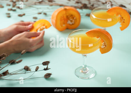 Halloween Cocktail, Kürbis orange Drink mit Gewürzen. DFestive Dekoration mit Blumen und Kürbisse wachen. Stockfoto