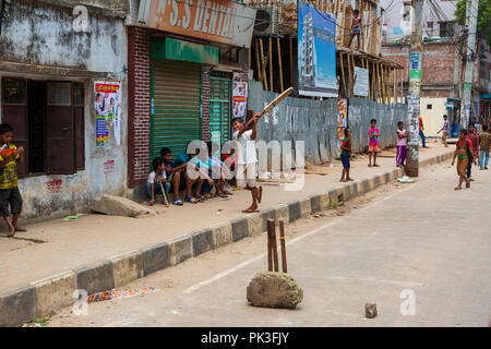 Kinder spielen ein Spiel der Straße Kricket in Dhaka, Bangladesh. Stockfoto