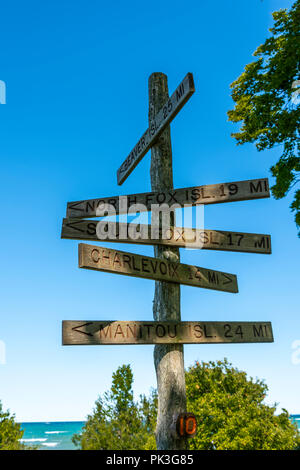 Holzschild am Grand Leuchtturm Traverse auf der Michigan Leelanau Peninsula verweist auf Beaver Island, Charlevoix, Lake Michigan und andere Inseln. Stockfoto