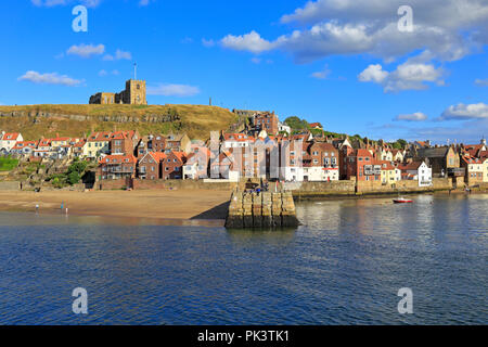 Str. Marys Kirche am East Cliff über Fischerhütten und Tate Hill Pier, niedrigere Hafen von Whitby, North Yorkshire, England, UK. Stockfoto