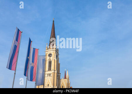 Der Name der Kirche, auch als Novi Sad katholische Kathedrale an einem sonnigen Nachmittag mit den Flaggen der Provinz Vojvodina, Serbien bekannt und Novi Sad. Th Stockfoto