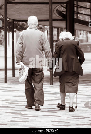 Ansicht der Rückseite des ältere Paare halten sich an den Händen. Großbritannien Stockfoto