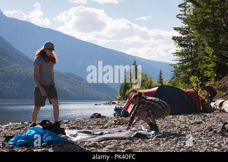 Paar einrichten Zelt in der Nähe des Riverside Stockfoto