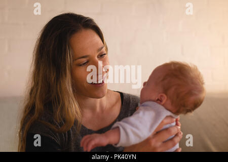 Mutter mit Baby auf Sofa spielen Stockfoto