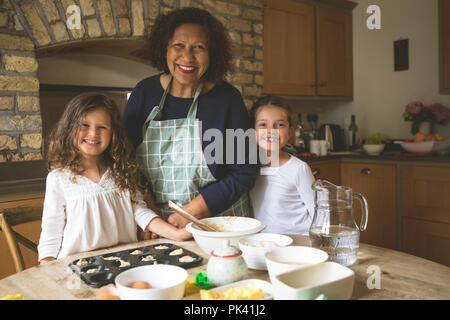 Großmutter stehen mit ihren Enkelinnen in der Küche Stockfoto