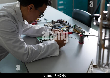 Männliche Wissenschaftler Experimentieren auf Platine Stockfoto