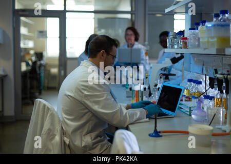 Männliche Wissenschaftler mit Laptop im Labor Stockfoto
