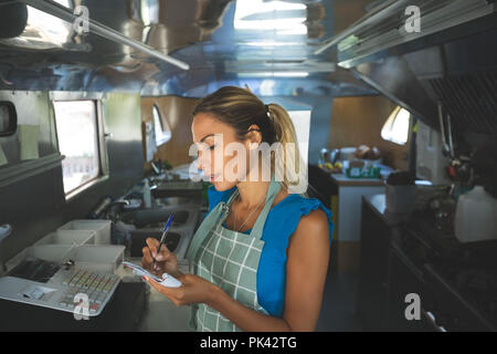 Frau Kellnerin Schriftform Aufträge auf Notepad Stockfoto