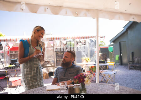 Weibliche Bedienung, die Reihenfolge, in der Outdoor Cafe Stockfoto