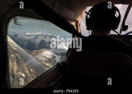 Piloten fliegen Flugzeuge über schneebedeckte Berge Stockfoto