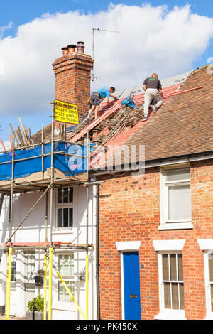 Dachdecker mit Gerüsten, die Dachlatten und Fliesen an einem alten Haus, kent, großbritannien, ersetzen Stockfoto