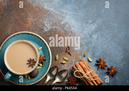 Indische Masala Chai Tee. Gewürzten Tee mit Milch auf dunklen Rusty Hintergrund. Stockfoto