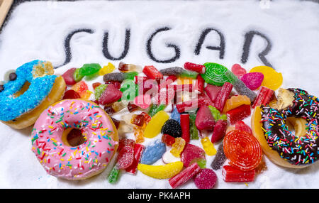 Mix von verführerischen Kuchen, Donuts und Bonbons mit Zucker ausbreiten und geschriebenen Text in ungesunde Ernährung, Schokolade Missbrauch Zucker Konzept, Körper Stockfoto