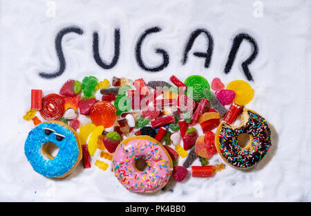 Mix von verführerischen Kuchen, Donuts und Bonbons mit Zucker ausbreiten und geschriebenen Text in ungesunde Ernährung, Schokolade Missbrauch Zucker Konzept, Körper Stockfoto