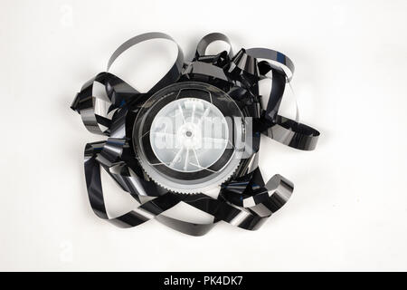 Alte VHS-Kassette mit aufgerollten Band. Beschädigte Datenträger für altes Haus, Bild- und Tonaufzeichnungen. Weißer Hintergrund. Stockfoto