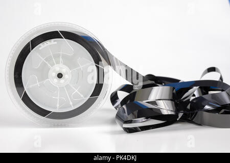 Alte VHS-Kassette mit aufgerollten Band. Beschädigte Datenträger für altes Haus, Bild- und Tonaufzeichnungen. Weißer Hintergrund. Stockfoto
