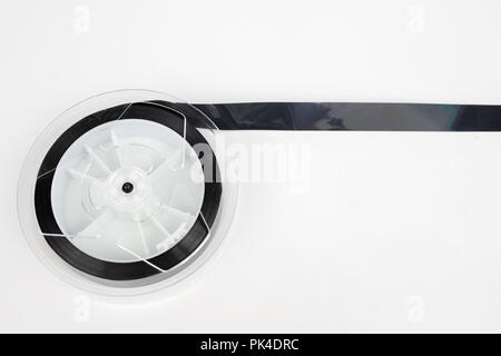 Alte VHS-Kassette mit aufgerollten Band. Beschädigte Datenträger für altes Haus, Bild- und Tonaufzeichnungen. Weißer Hintergrund. Stockfoto