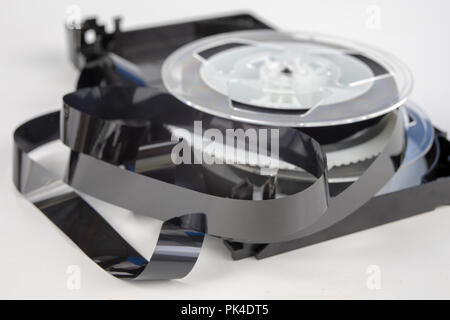 Alte VHS-Kassette mit aufgerollten Band. Beschädigte Datenträger für altes Haus, Bild- und Tonaufzeichnungen. Weißer Hintergrund. Stockfoto