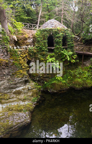 Die Einsiedelei in Tollymore Forest Park, ist ein hübscher Stein Schutz in Efeu bedeckt am Riverwalk entlang des Flusses Shima, Newcastle, County Down, N. Stockfoto