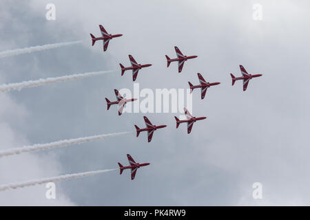 Fliegen in Formation - Die roten Pfeile, die Royal Air Force Kunstflug Team, auf der Airshow über Carrickfergus Castle, County Antrim, Nordirland. Stockfoto