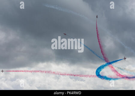 Pause Bildung - die roten Pfeile, die Royal Air Force Kunstflug Team, auf der Airshow über Carrickfergus Castle, County Antrim, Nordirland. Stockfoto