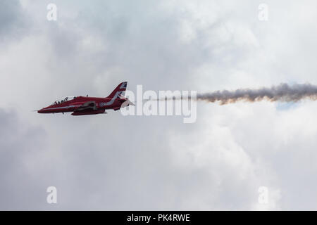 Solo Flugzeug - Die roten Pfeile, die Royal Air Force Kunstflug Team, auf der Airshow über Carrickfergus Castle, County Antrim, Nordirland. Stockfoto