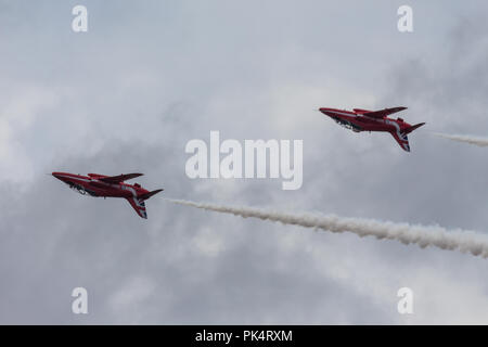 Auf den Kopf gestellt - die roten Pfeile, die Royal Air Force Kunstflug Team, auf der Airshow über Carrickfergus Castle, County Antrim, Nordirland. Stockfoto