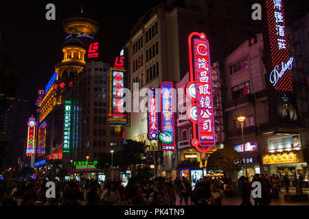 Shanghai, China - Dezember 12, 2014: Leuchtreklamen und Geschäfte und Menschen in der Nacht entlang der Nanjing Road, Shanghai's Premier Shopping Street Stockfoto